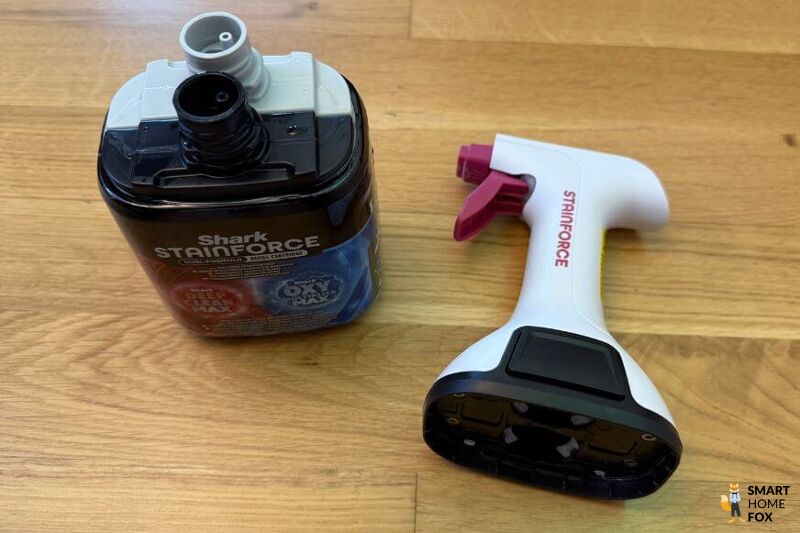 Die originale Shark Reinigungslösung für den Stainforce ist zu sehen und die Sprühflasche die Du aufstecken kannst steht daneben.